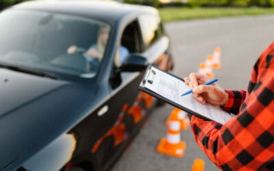 Instructor with checklist and woman in car, exam